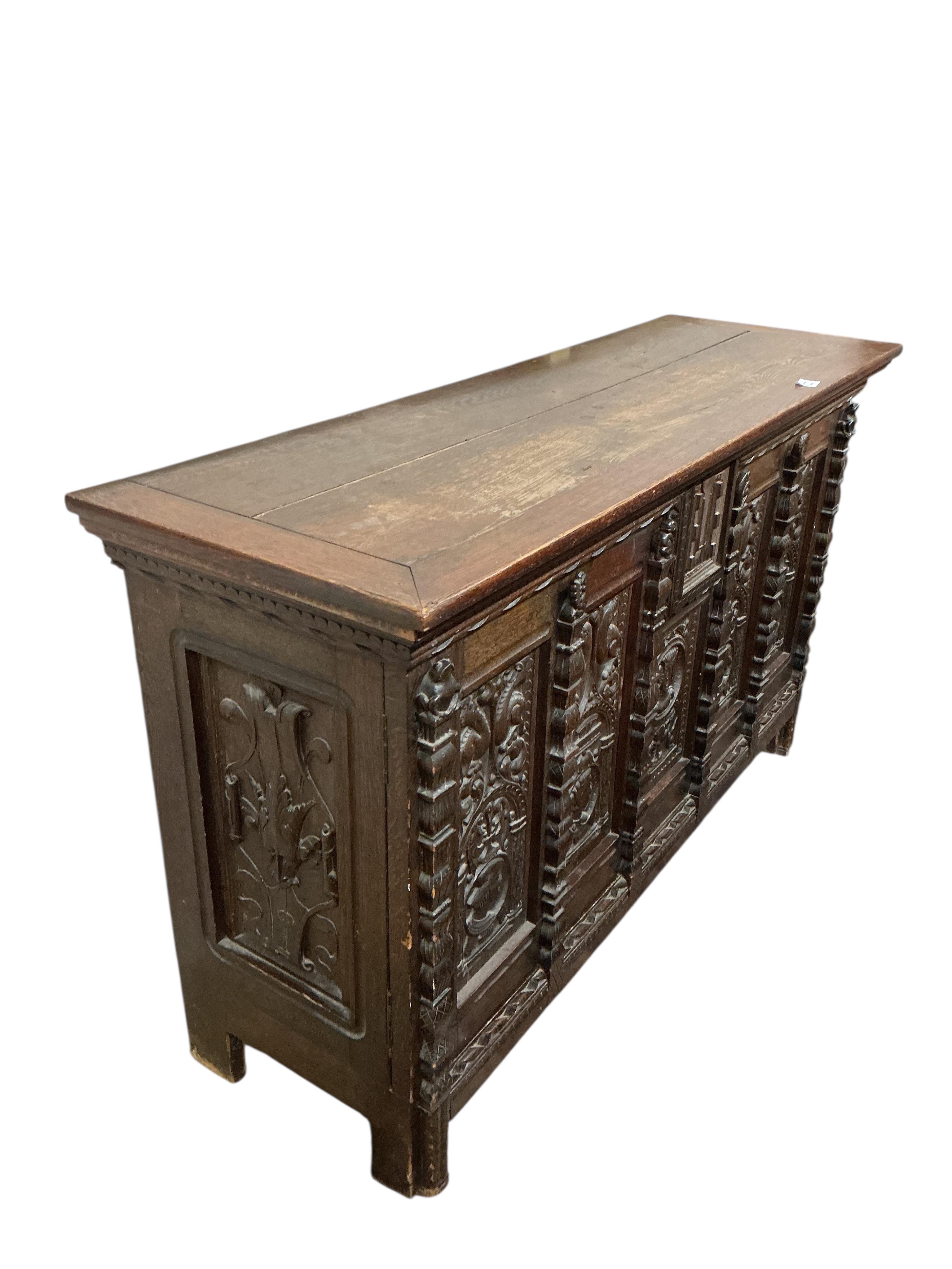 A 17th century style carved oak side coffer, width 145cm, depth 47cm, height 86cm